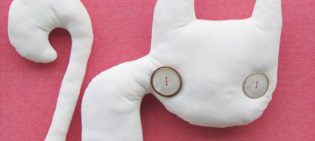 Goldener rahmen. rosa Hintergrund, stoffkatze, Knopfaugen, Perlmutt, weißer Stoff