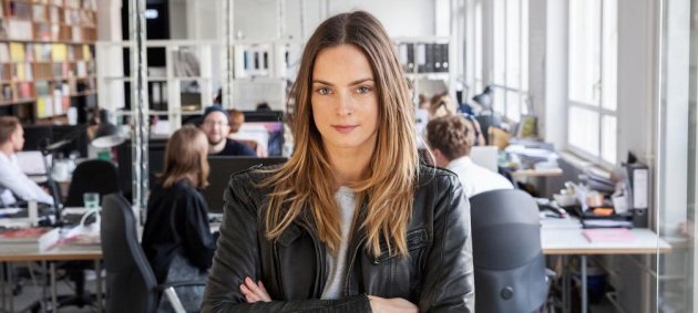 Filippa von Stackelberg, Büroraum, Frau mit verschränkten Armen, Bürostühle, Lederjacke, blonde Haare, graues Shirt, verschränkte Arme